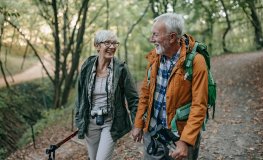 Couple senior heureux qui marche en pensant à son assurance santé 