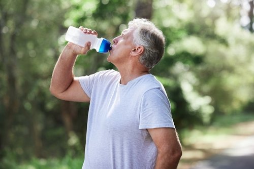 homme qui boit de l’eau pour se protéger de la canicule